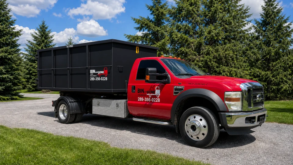 Bin and Gone red truck carrying a black rental bin